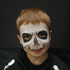 Child wearing a zombie face paint design made with the Halloween kit