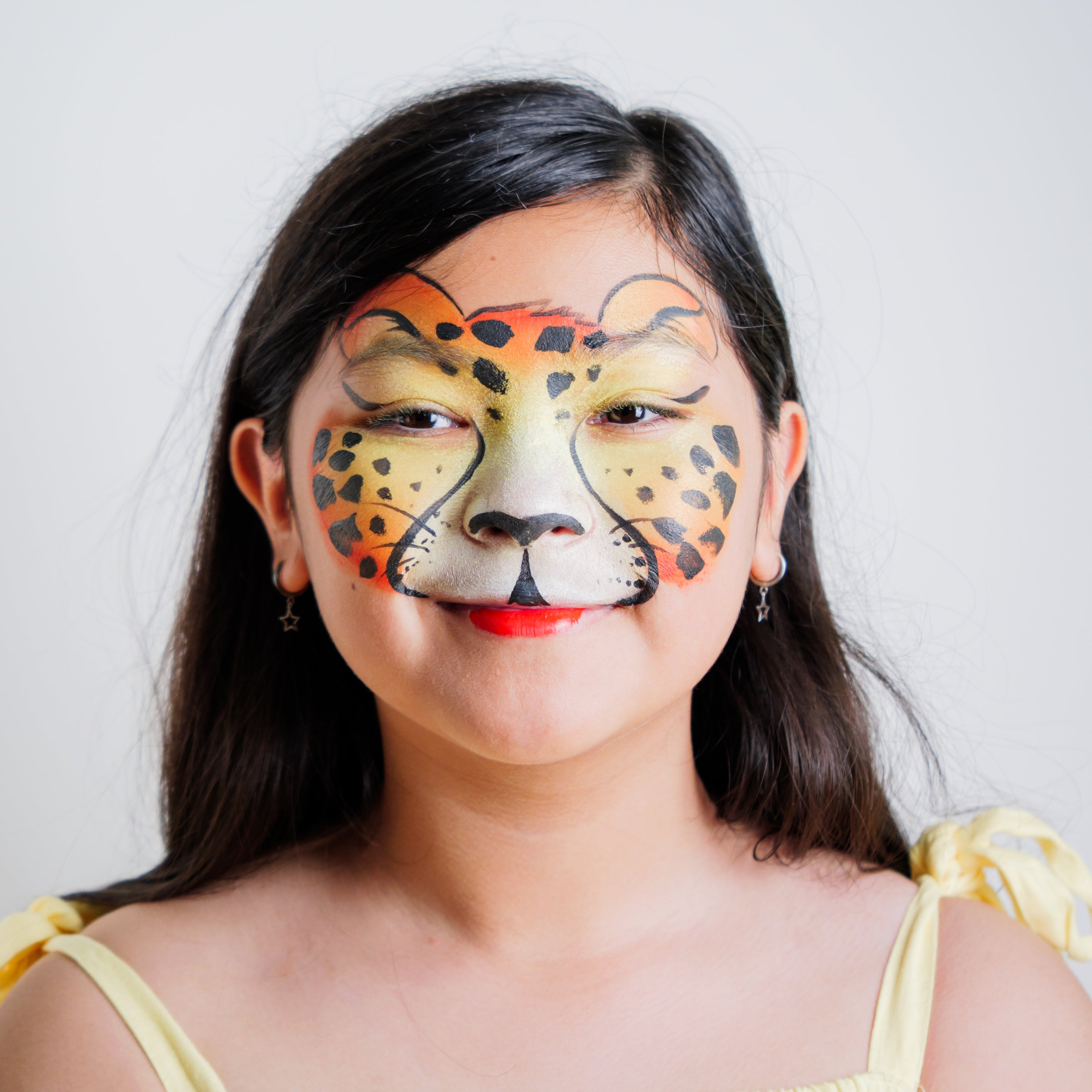 Child wearing a tiger face paint design created with the Animal Kingdom kit