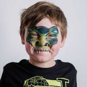 Child wearing a T-Rex dinosaur face paint design created with the Dino & Dragon kit