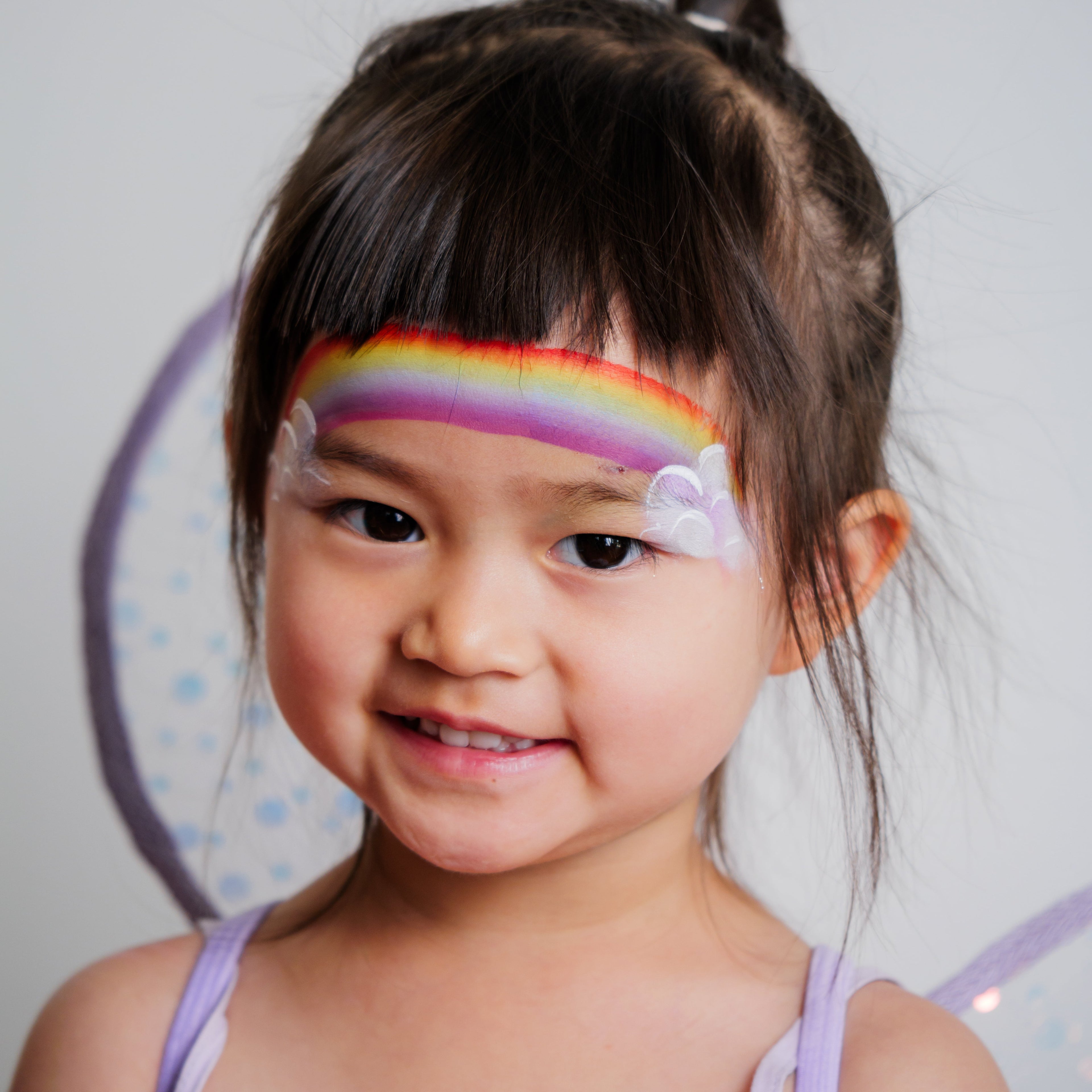 Child wearing a butterfly face paint design created with the Imagination kit