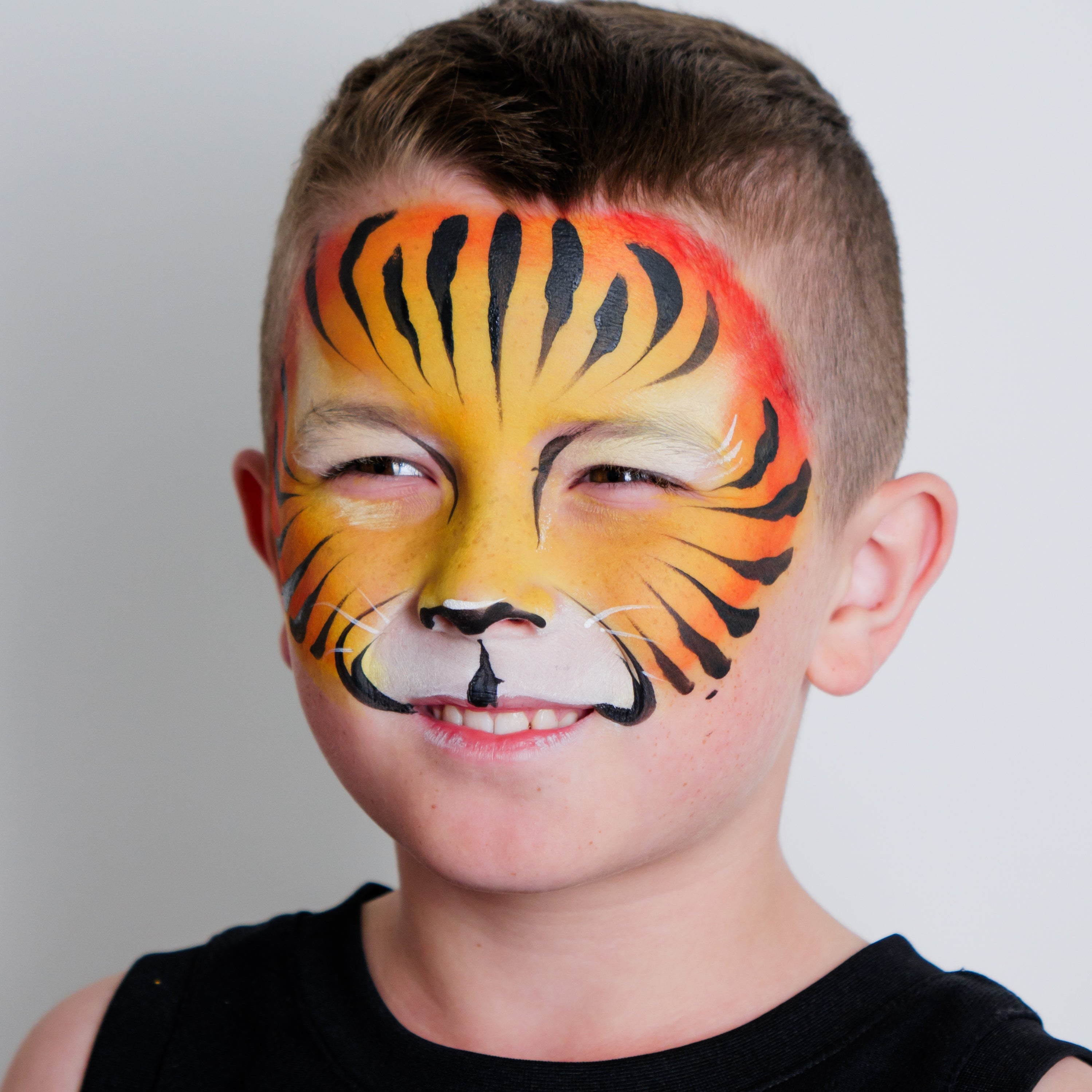 Child wearing a colourful rainbow face paint design made with the Imagination kit
