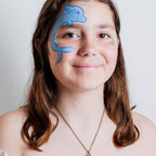 Parent painting a child's face at home using the Palette Pals Oceans Adventure kit