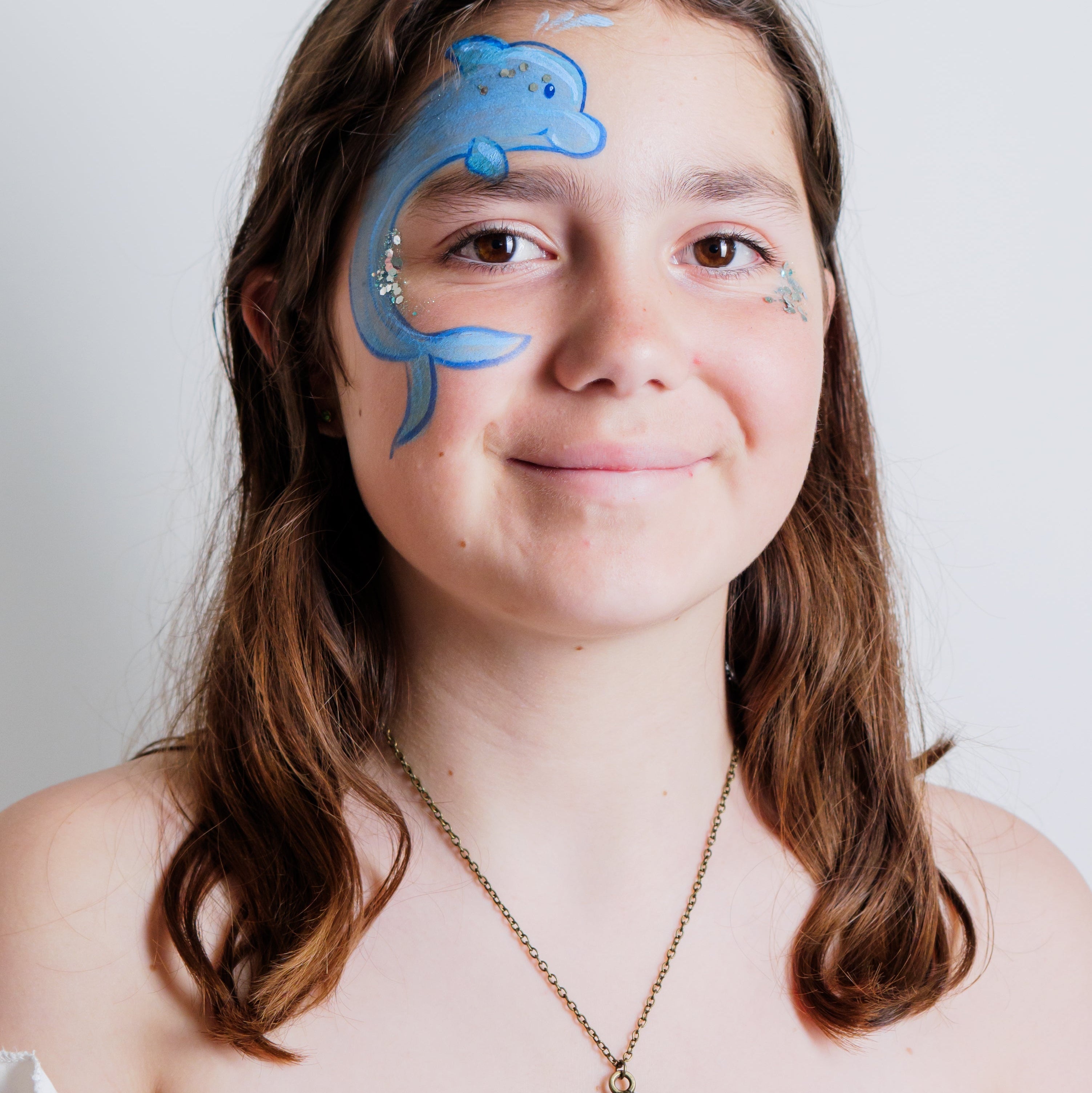 Parent painting a child's face at home using the Palette Pals Oceans Adventure kit