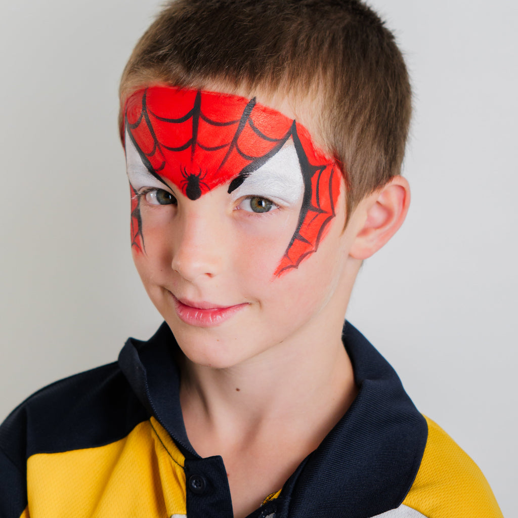 Child smiling with a finished face paint design from the Imagination kit