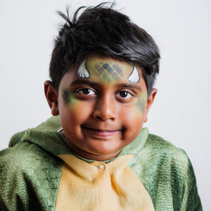 Parent painting a child's face at home using the Palette Pals Dino & Dragon kit