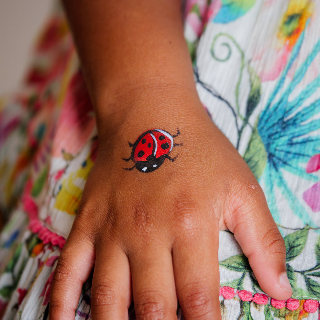 Child smiling with a finished garden-themed face paint design from the Garden Party kit
